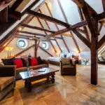 Wohnzimmer unter Dachbalken mit Couchtisch

