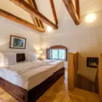 Schlafzimmer mit offenen Balken und Bett

