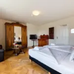 Doppelzimmer mit Holzschrank und Bett

