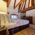 Schlafzimmer mit Holzbalken und gemütlichem Bett

