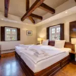 Zimmer mit Doppelbett und freiliegenden Balken

