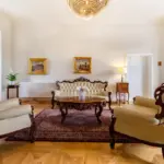 Wohnbereich mit Sofa und antiken Möbeln

